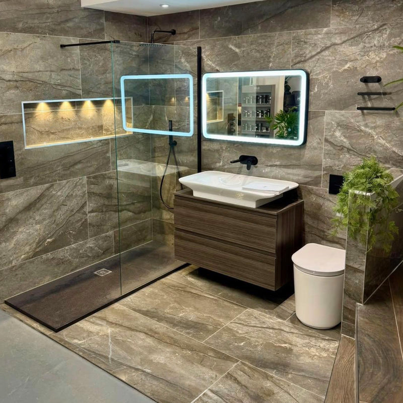 Modern bathroom with stone tiles, a shower, sink, and toilet.